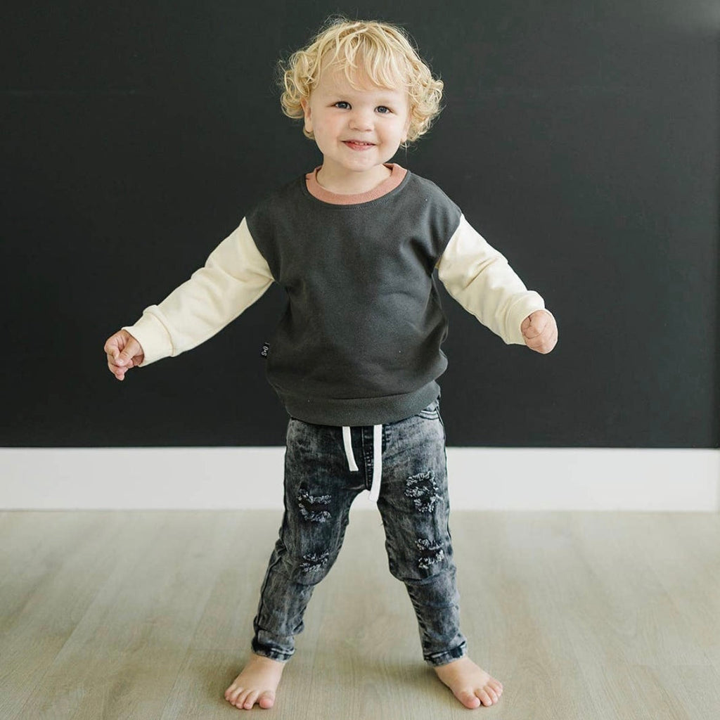  Happy toddler modeling the Olive + Scout Ryker Crewneck Sweatshirt